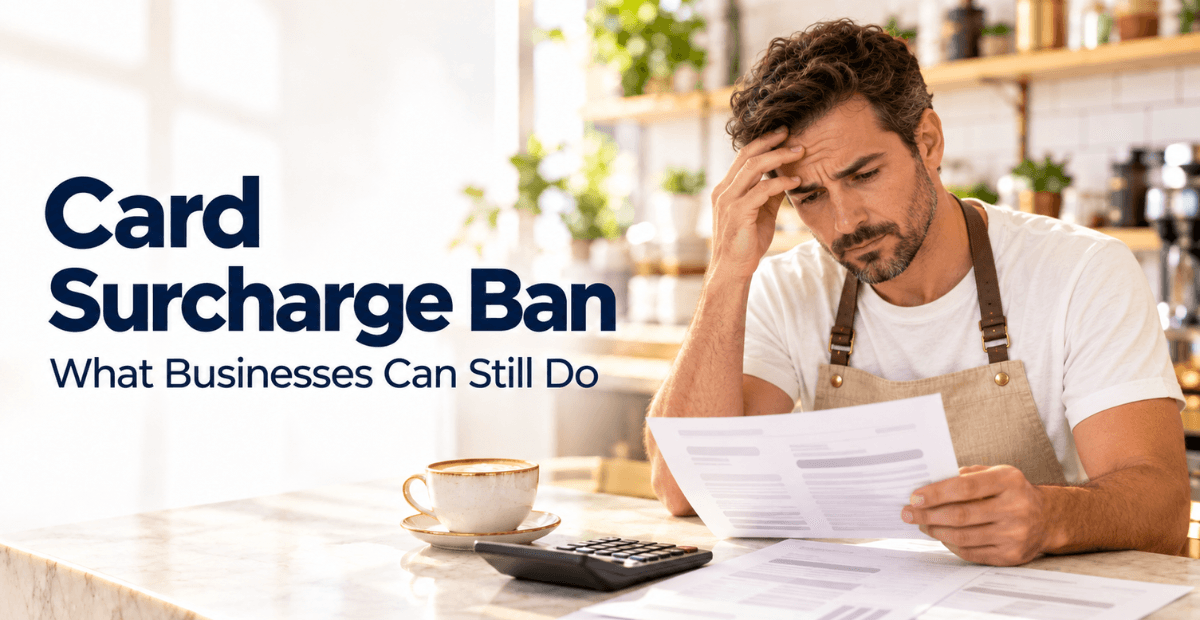 Business owner in an apron reviewing a payment statement beside a calculator and coffee, with the title Card Surcharge Ban: What Businesses Can Still Do