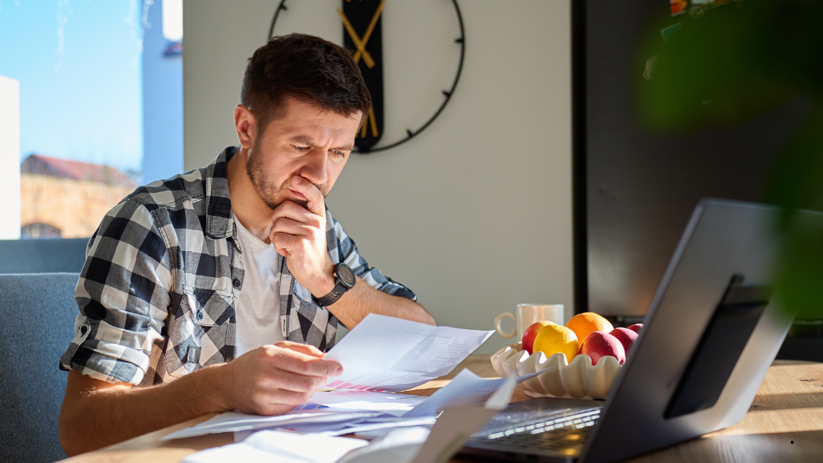 Australian merchant reviewing payment terminal costs with a calculator and notebook